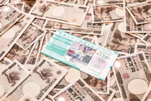 たくさんの一万円札と宝くじの画像